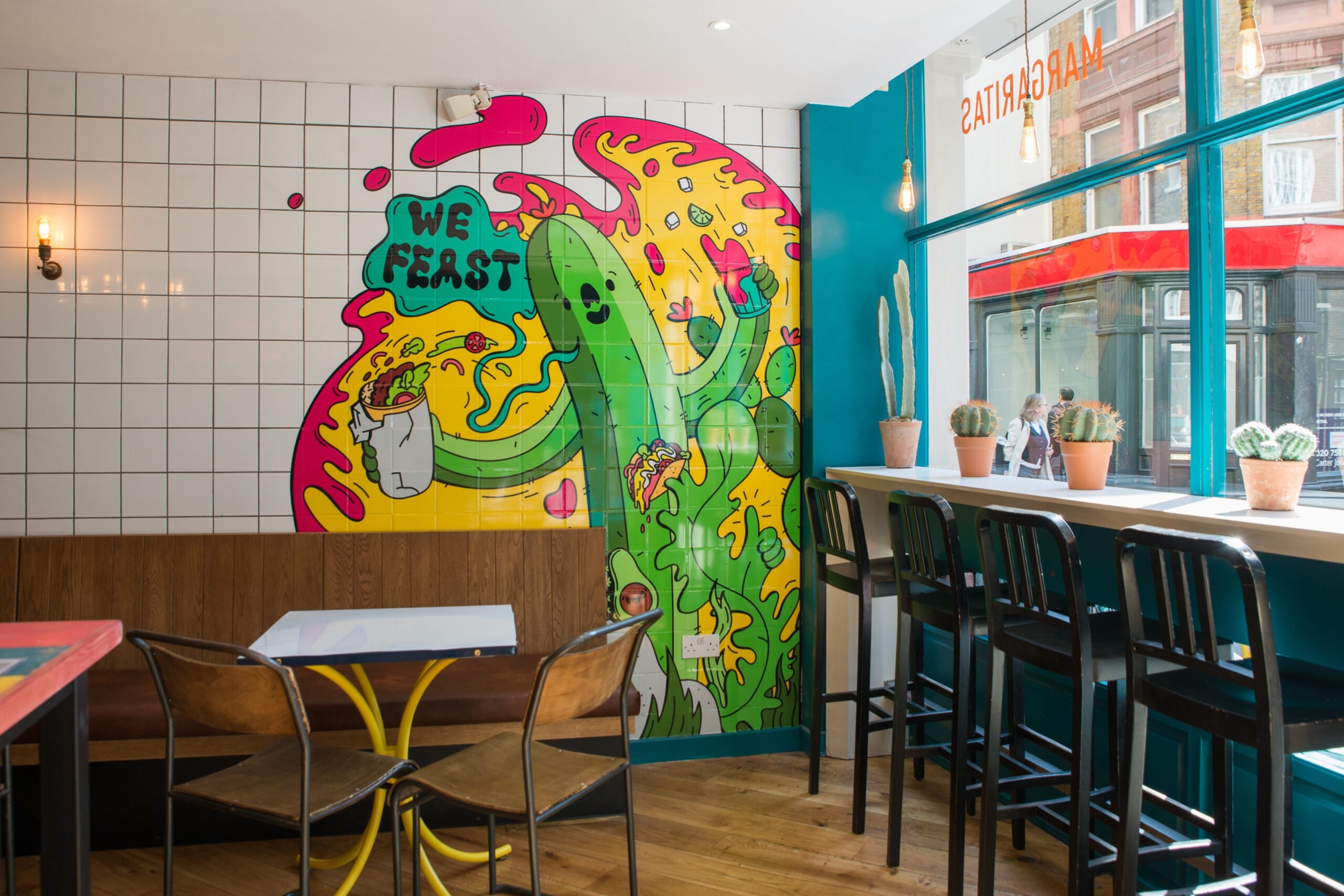 A vibrant restaurant featuring colorful walls and tables, creating a lively and inviting atmosphere.
