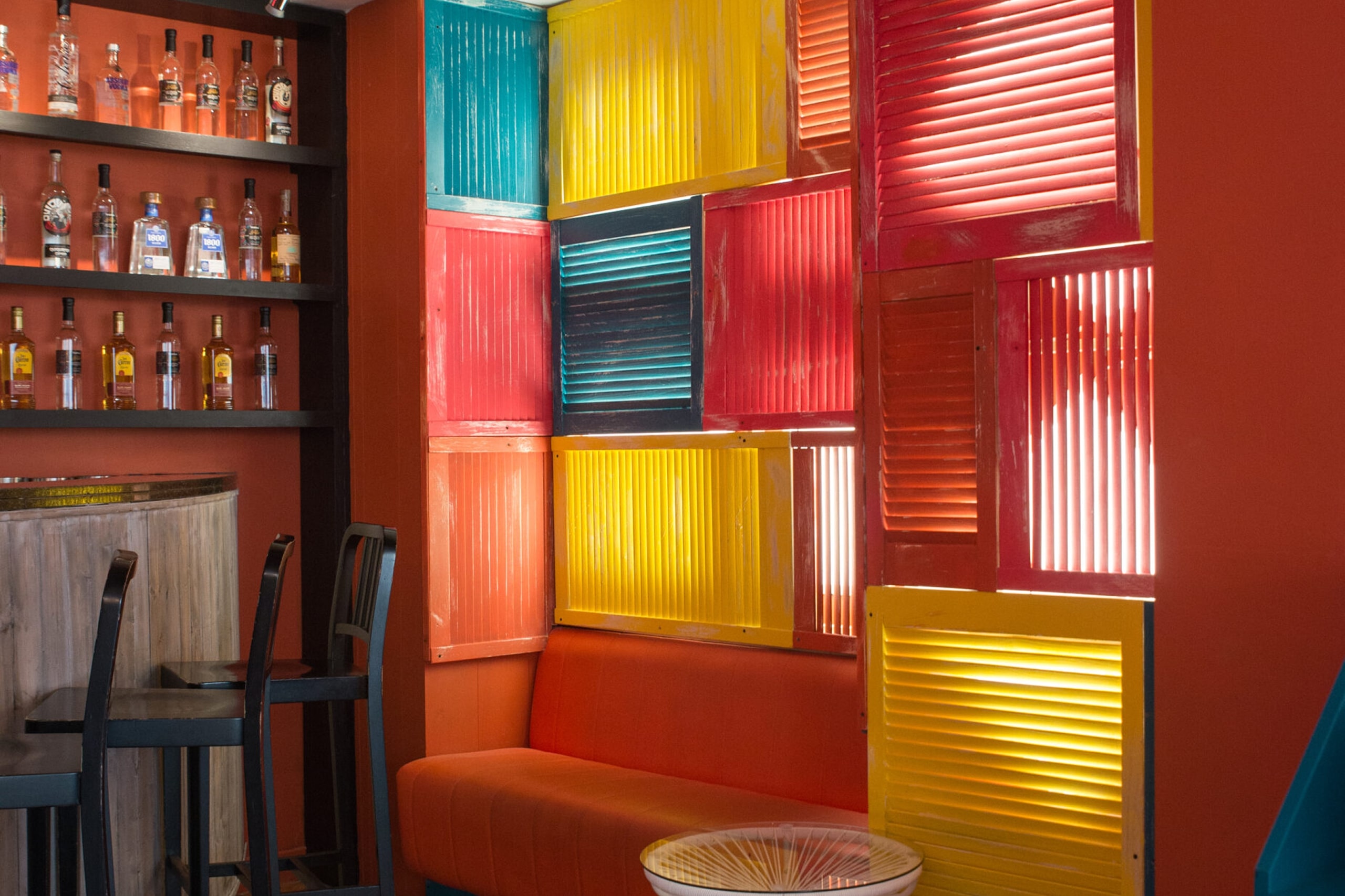 A vibrant wall featuring colorful shutters in various shades, adding charm and character to the scene.